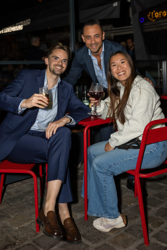 Trois amis en terrasse sur les chaises rouges