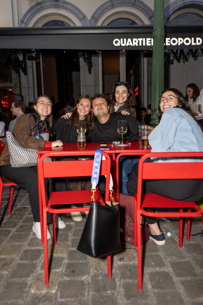 Amis attablés devant la façade du Quartier Leopold